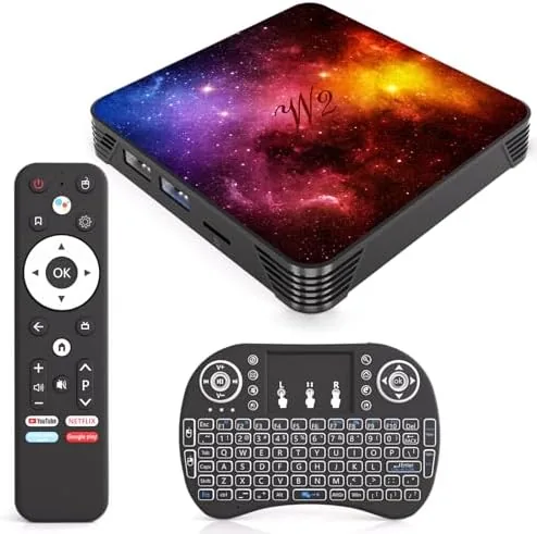 The Android 14 TV box and mini keyboard on a media console below a wall mounted TV