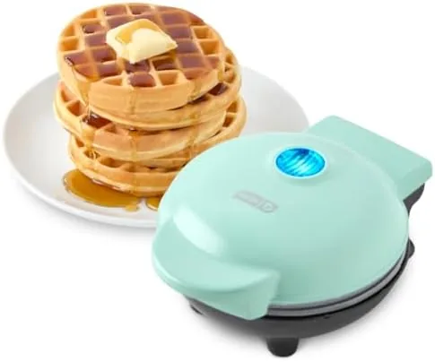 The aqua Dash Mini Waffle Maker sitting on a kitchen counter