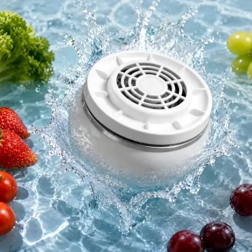 The wireless fruit washer sitting in a basin of water beside fresh produce