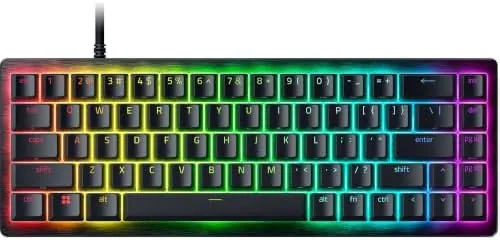 The Razer Huntsman V3 HE Mini 65% keyboard on a gaming desk with RGB lighting
